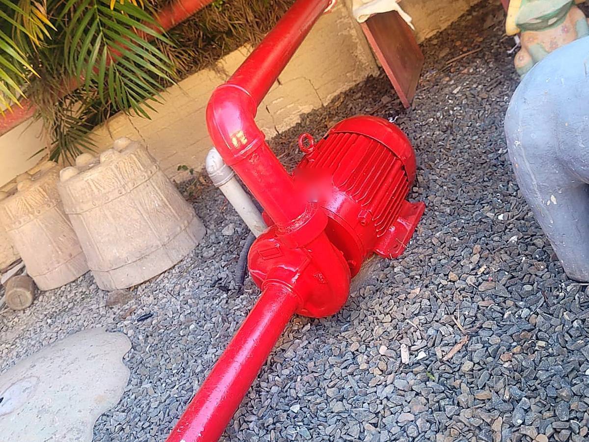 Bomba de recalque instalada em área externa, com tubulação alinhada e pintada